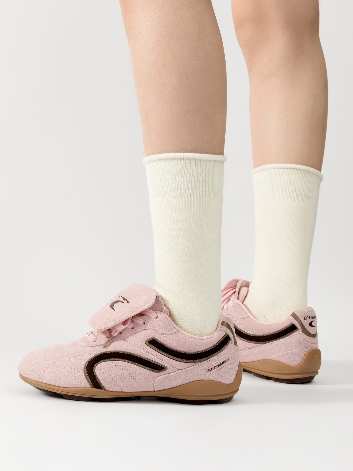 Ivory crew socks with rolled cuffs worn with pink sneakers